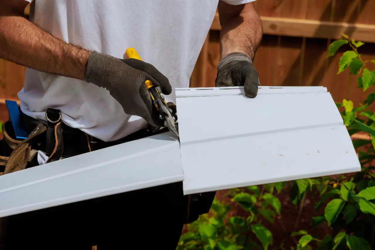 Worker cutting vinyl siding for home installation